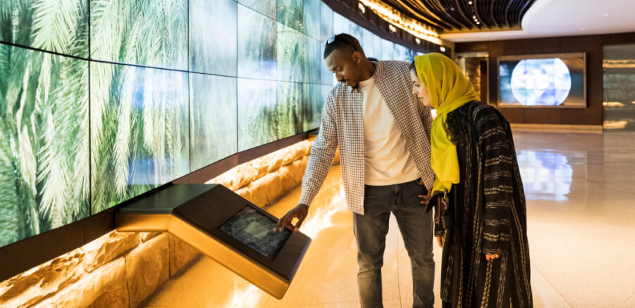 Two people pointing at a screen in a modern room